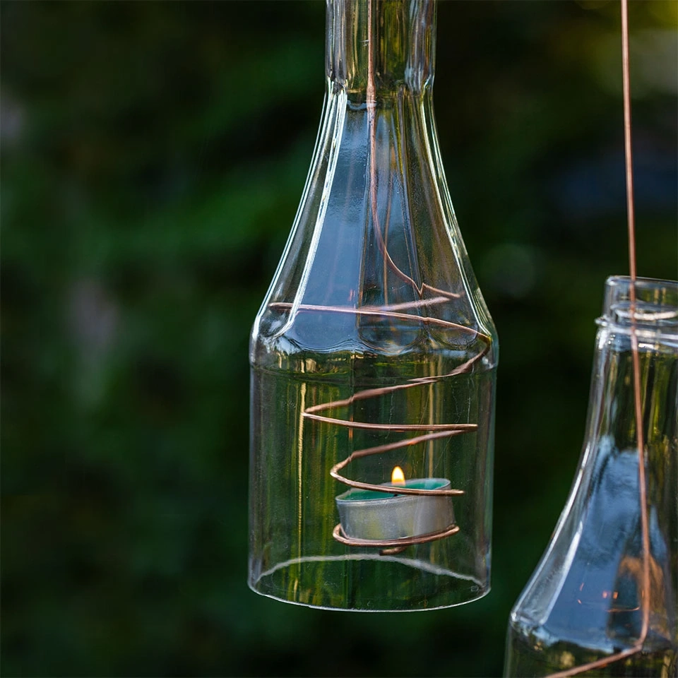 Glasflaschenlaternen mit Kerzenlicht und Kupferdraht