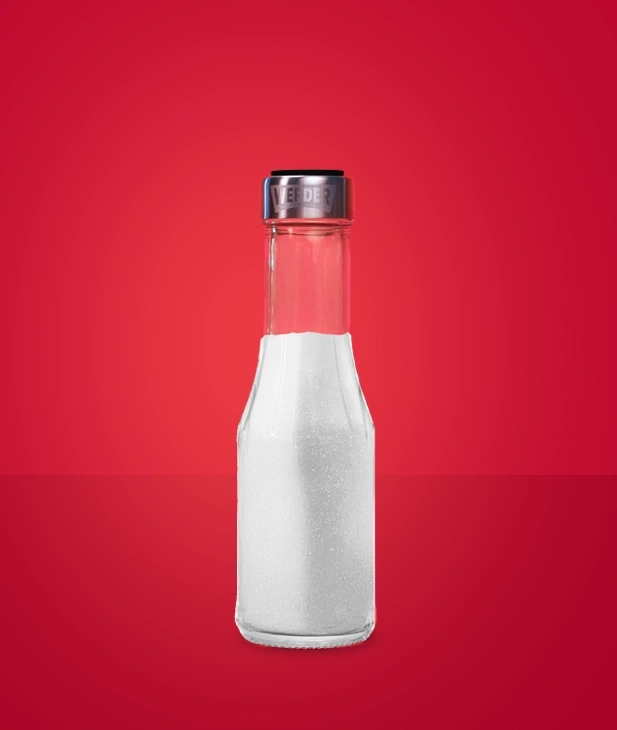 Eine Glasflasche mit Zucker und einem silbernen Deckel auf rotem Hintergrund.